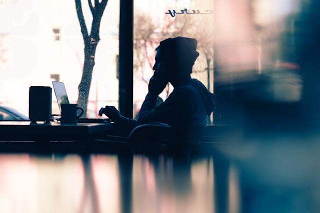 Homem mexendo no notebook. Esta imagem ilustra uma pessoa refletindo sobre os mitos sobre o mercado de câmbio que divulgamos no Dia da Mentira.