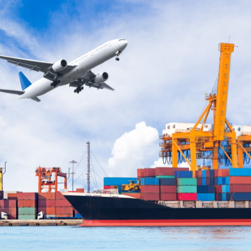 Imagem de um porto com um navio, um avião e diversos containers. Empresas que fazem importação ou exportação precisam de serviços de câmbio.