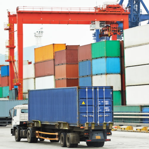 Imagem de um caminhão carregando um container para uma empresa de importação que precisa de serviços de câmbio.