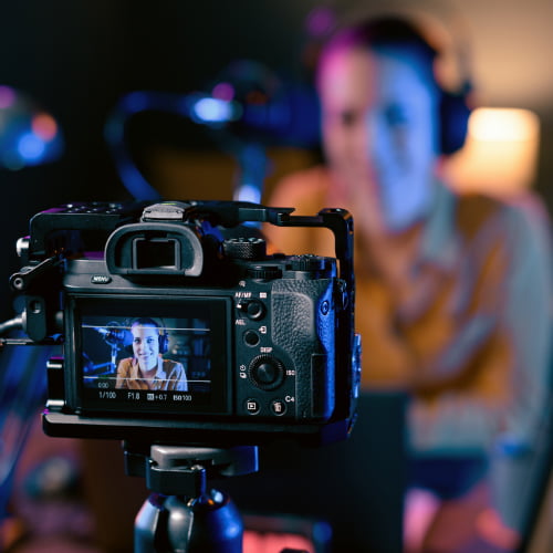 Imagem de um Youtuber usando uma câmera para gravar vídeos. Para receber a monetização do YouTube é necessário um serviço de câmbio.