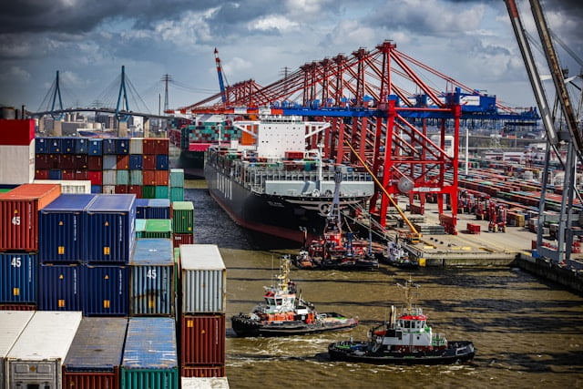 Imagem de embarcações, carregando produtos importados, ilustrando o processo de comércio exterior, com foco no fechamento de câmbio na importação.