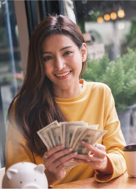 Imagem de uma mulher sorridente segurando notas de dólar. Ela encontrou uma empresa de câmbio especializada, a B2Gether e conseguiu economizar.