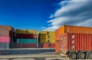 Esta imagem mostra contêineres em um porto com produtos que passam por processos de exportação, ilustrando o ranking dos produtos que o Brasil mais exporta. O ranking foi elaborado pela B2Gether, empresa de câmbio especializada em operações financeiras de exportação.