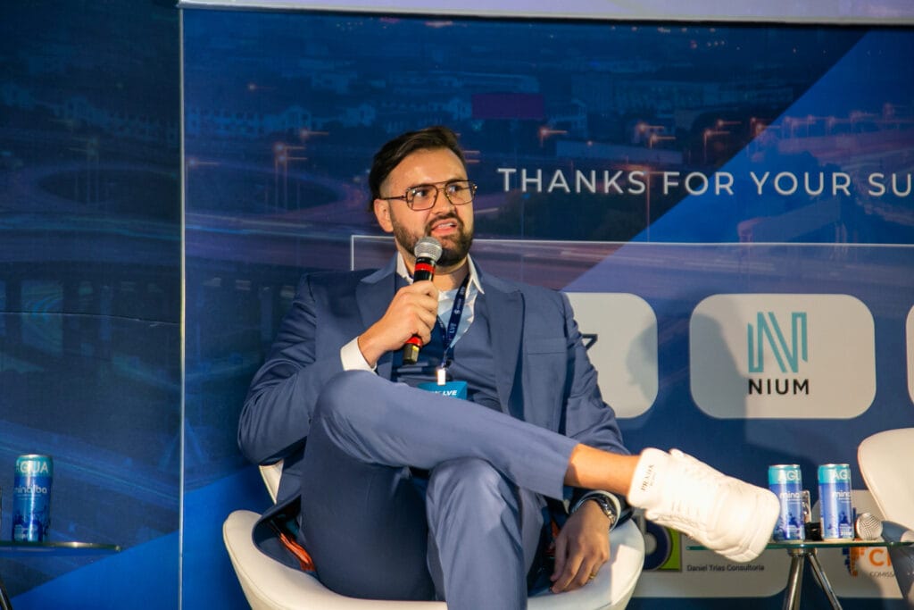Diego Zia, sócio-fundador da B2Gether, empresa de câmbio especializada em operações financeiras de importação, exportação e remessas internacionais. Na imagem, Diego está realizando uma palestra em um evento internacional, falando sobre câmbio empresarial.